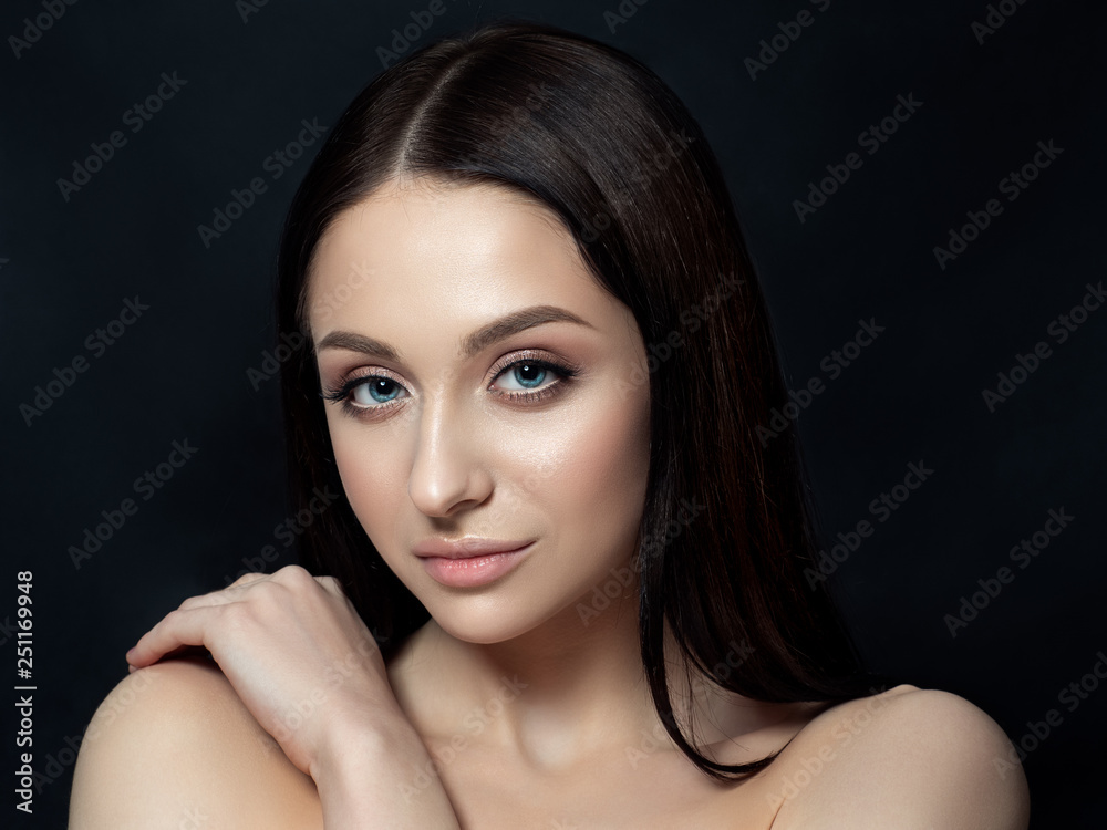 Portrait of beautiful brunet woman with nude makeup over black background. Luxury skincare concept. Studio shot. Portrait of beautiful brunet woman with nude makeup over black background. Luxury skincare concept. Studio shot.