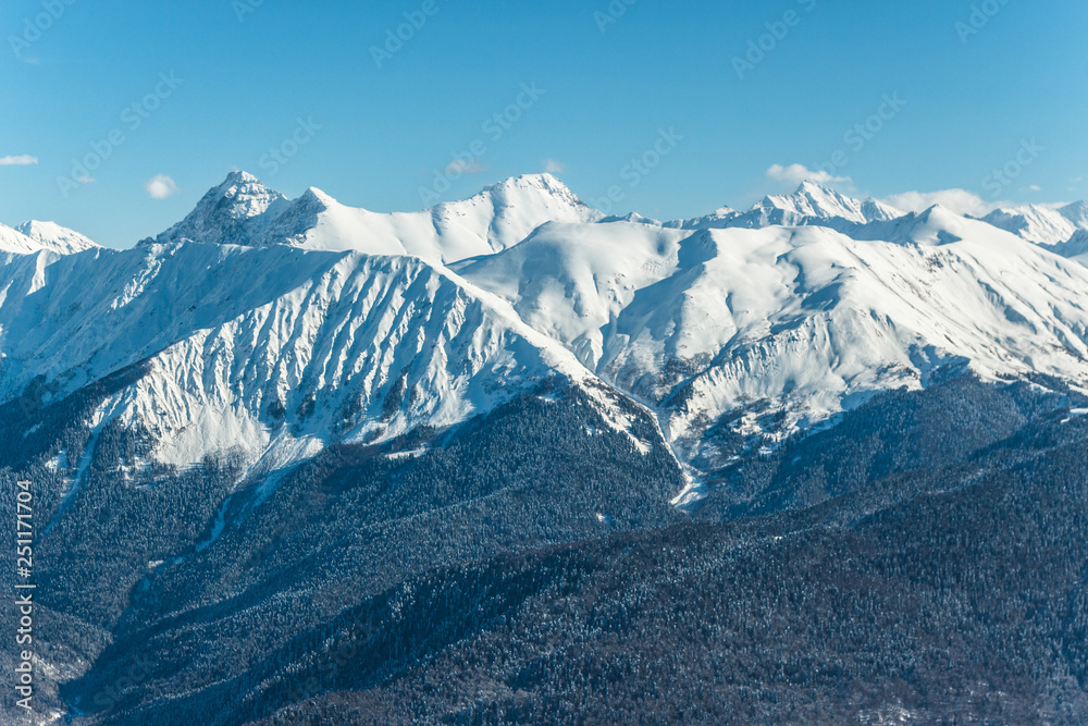Beautiful landscape view of mountains covered on snow with dark and brown hills in the foreground