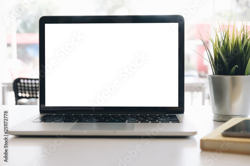 Mockup blank screen laptop on desk in office room background.