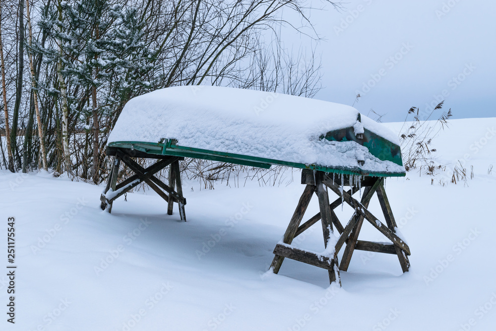 Green boat covered with snow Green boat covered with snow