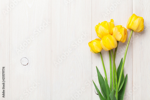 Yellow tulips on wooden table