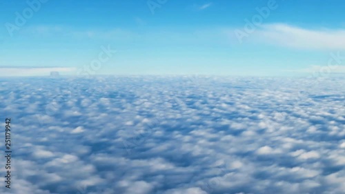 View from the porthole to the field of bright clouds during the flight of the aircraft