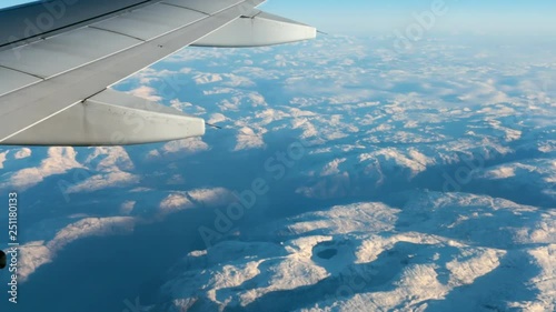 View from the porthole to the mountain and wing of airplane during the flight of the aircraft