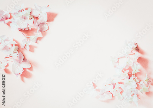 Styled feminine flat lay on pale pastel pink background, top view. Minimal woman's desktop with blank page mock up, spring lilac flower, Creative concept 