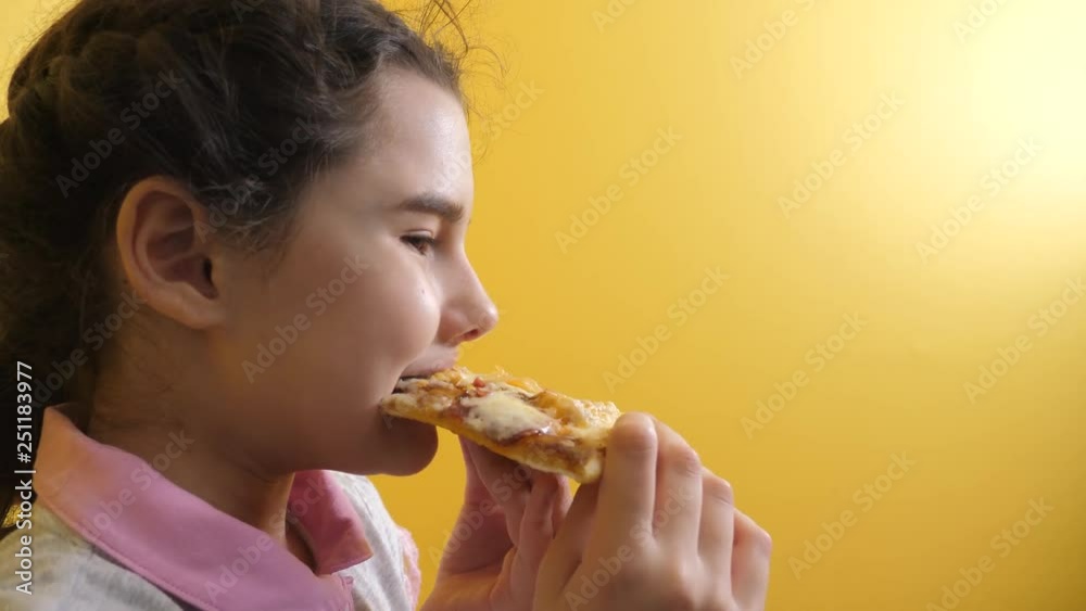 happy little girl eating a slice of pizza concept. teenager child hungry eats a slice of lifestyle pizza. slow motion video. pizza fast food concept happy little girl eating a slice of pizza concept. teenager child hungry eats a slice of lifestyle pizza. slow motion video. pizza fast food concept