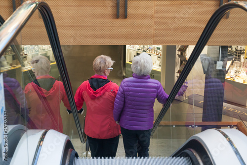 KOTKA, FINLAND - SEPTEMBER 27, 2018: Two woman on the escalator in the Shopping Center Pasaati. Town is located in The Kymenlaakso Region of Finland. photo