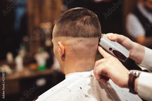 Professional haircut with electric razor in barbershop salon