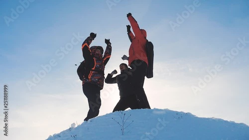 teamwork winners. group team tourist hikers success win winter reached the top of the mountain silhouette sunlight. tourists climbers climb jumping rejoice to the top of mountain teamwork business