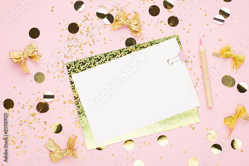 Blank sheet of paper, notebook on a festive pink background with golden confetti and glitter. Universal background for a project of a birthday party, wedding. Flay lay, copy space