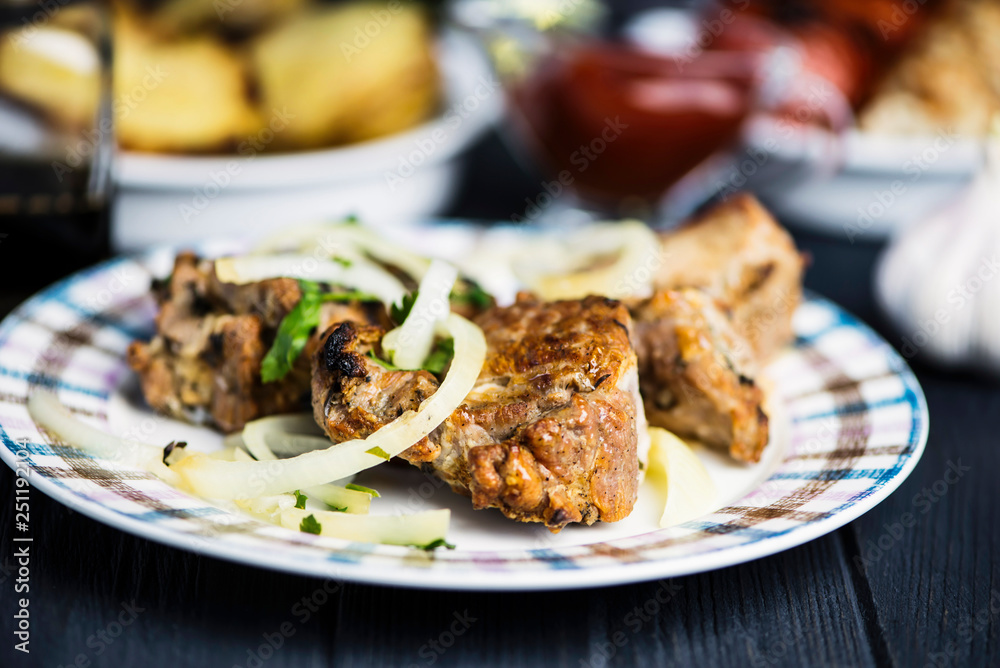 Pork meat barbecue with marinated onions on a wooden background Pork meat barbecue with marinated onions on a wooden background