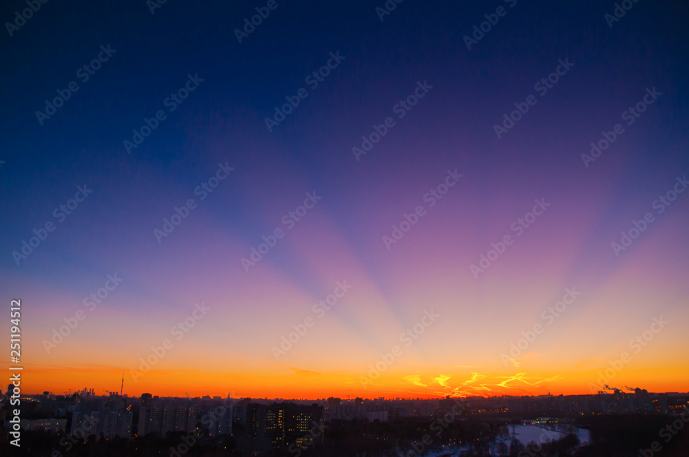 Orange clouds with aircraft trails sky background and city light midnight evening time