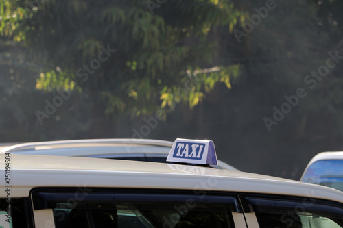 Taxi light sign or cab sign in white and blue color with white text on the car roof.