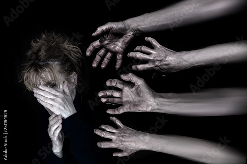 An anxious woman tries to protect herself with her hands. Hands reach for her.