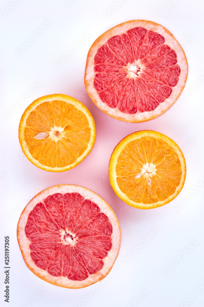 Sliced grapefruit and orange, top view. Ripe grapefruit and orange cut in halves on light background. Ingredients for healthy beverage. Sliced grapefruit and orange, top view. Ripe grapefruit and orange cut in halves on light background. Ingredients for healthy beverage.