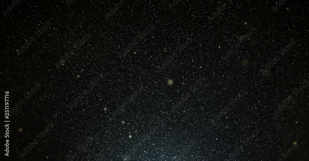Fototapeta premium Snow flies in the sky at night as a background