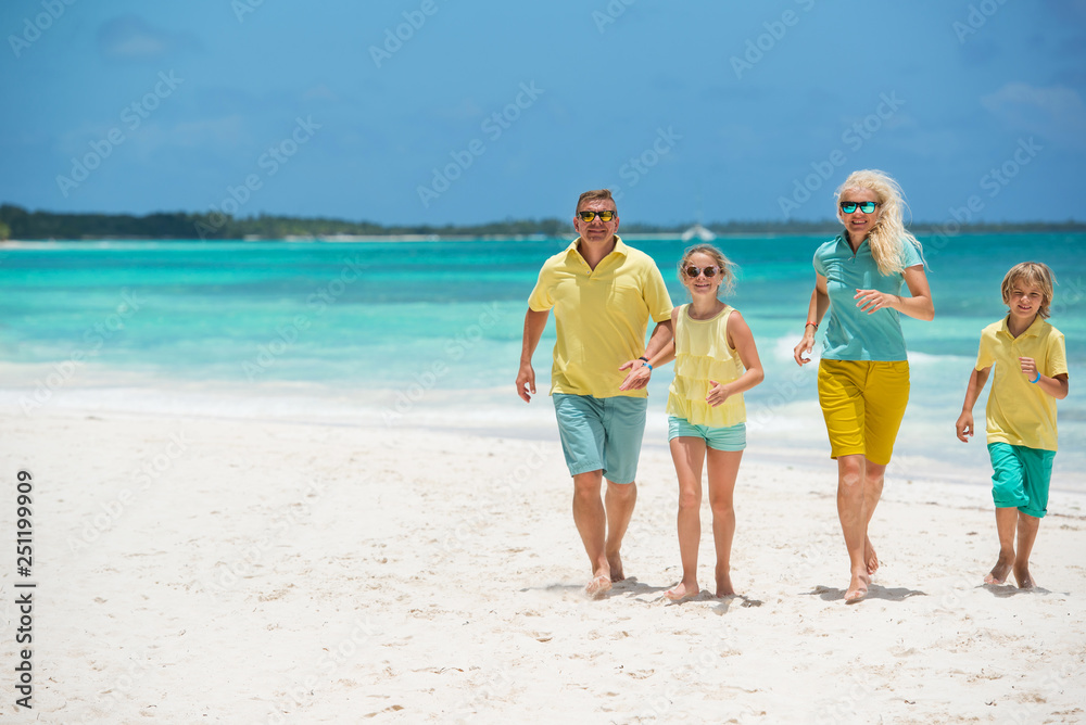 Happy family at the tropical beach during summer vacation 