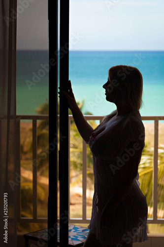 Sexy woman silhouette at the balcony with sea view. © lookproduction