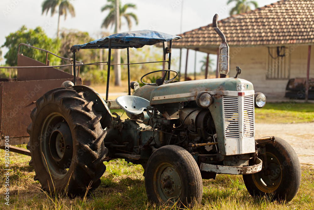 Old gray rusty tractor in a field or farm Old gray rusty tractor in a field or farm