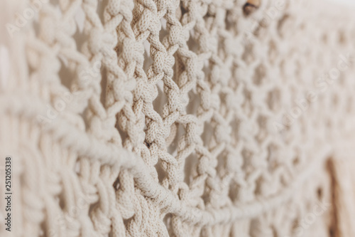Canvastavla Detail of cream macrame decor displayed hanging on a wall.