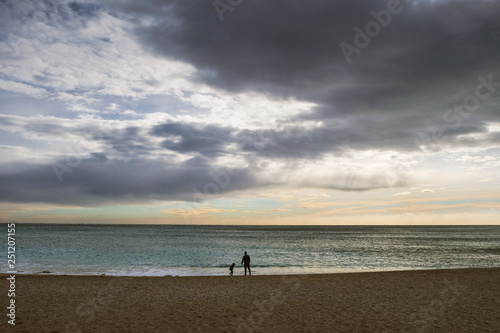 Silhouette of boy with daddy walking along the Mediterranean sea in winter. Winter tourism in Provence. Self-isolation concept. Changing the philosophy of life concept.