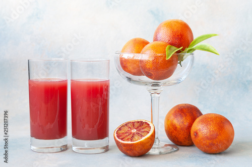Close-up of Two glasses of cold fresh blood orange juice and blood oranges.