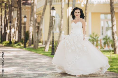 Beautiful bride in a white wedding dress on outdoors.