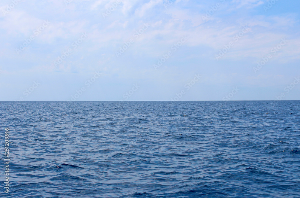 Seascape with sea horizon and almost clear deep blue sky. Background