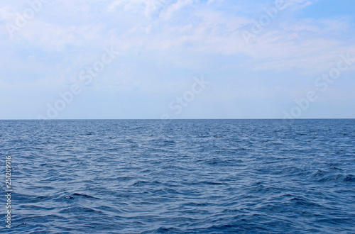 Seascape with sea horizon and almost clear deep blue sky. Background