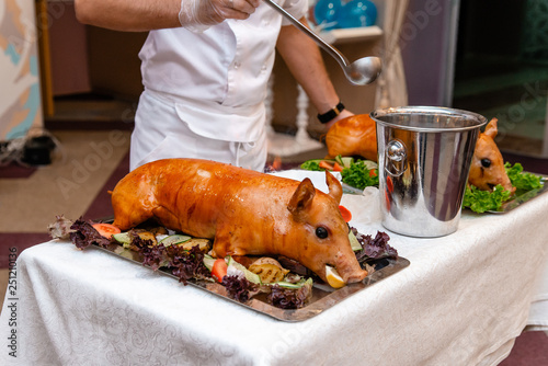 Roasted pork ready for serving. Grilled piglet with head.