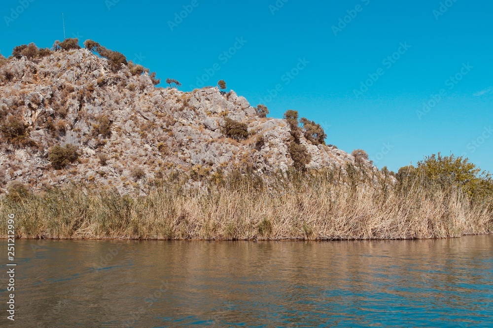 Mountains with dry grass and faded trees near the river