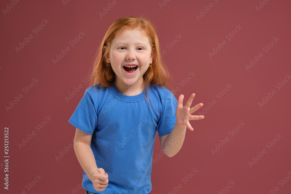 Portrait of cute redhead emotional little girl on red background Portrait of cute redhead emotional little girl on red background