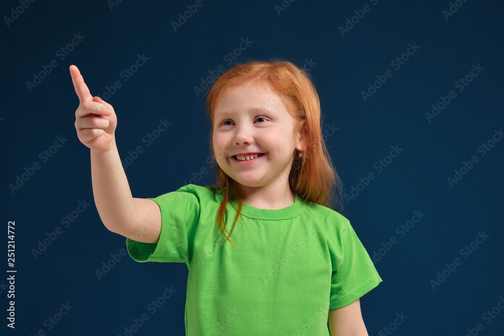 close up photo of little redhead emotional girl posing before camera on blue background