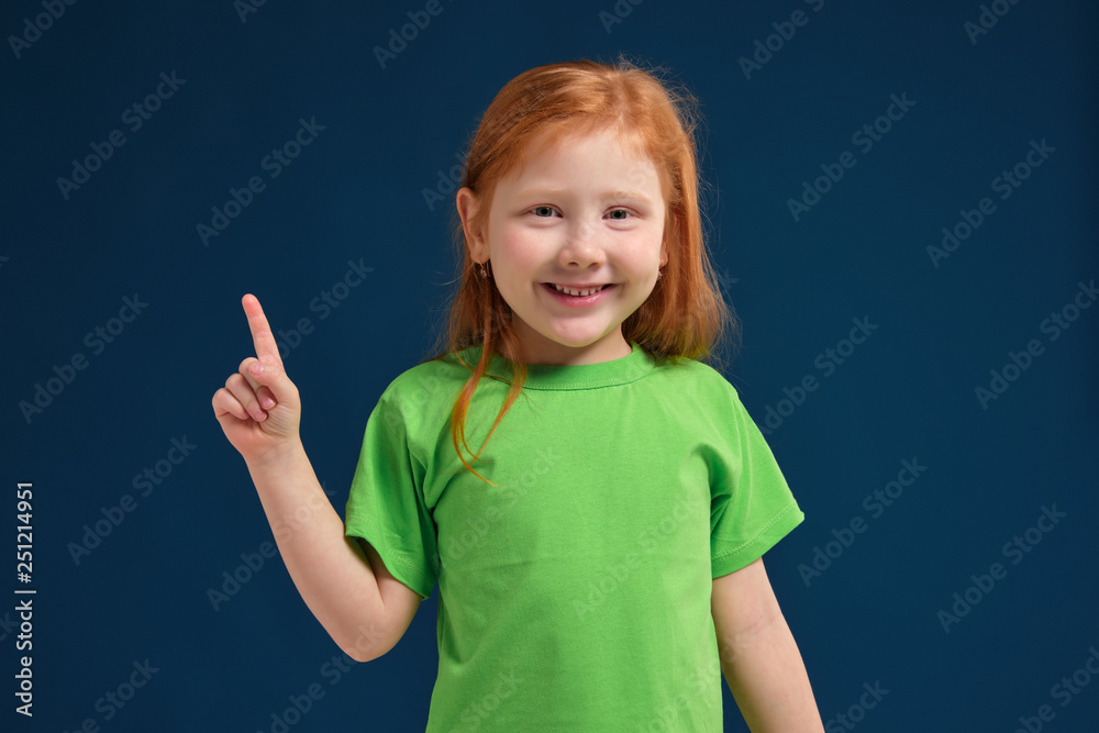 close up photo of little redhead emotional girl posing before camera on blue background close up photo of little redhead emotional girl posing before camera on blue background
