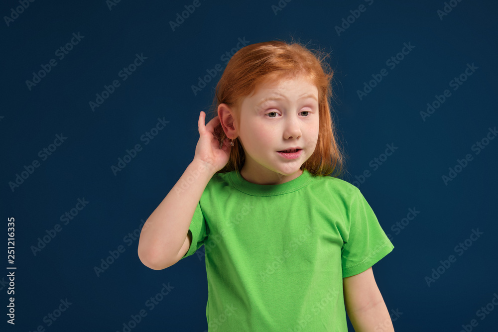close up photo of little redhead emotional girl posing before camera on blue background close up photo of little redhead emotional girl posing before camera on blue background