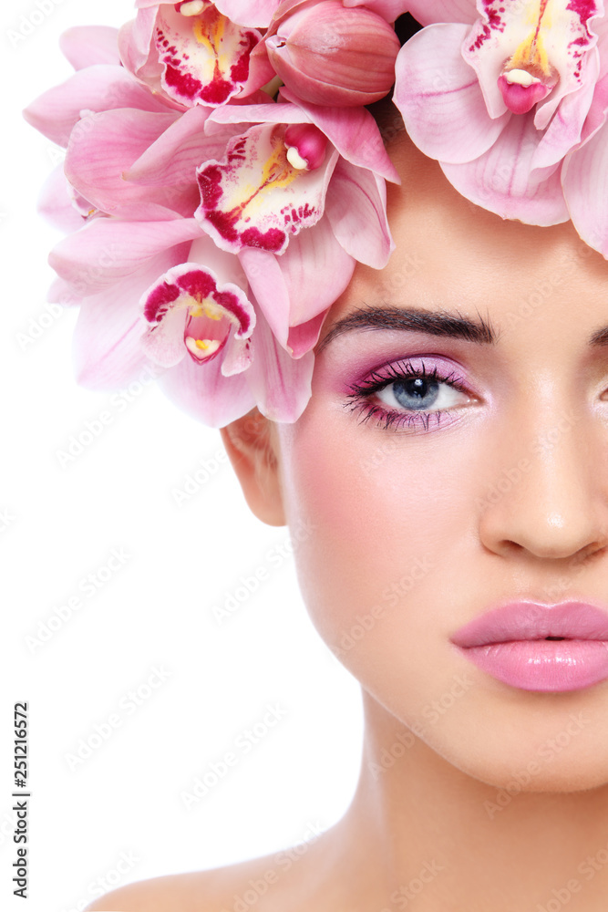 Close-up portrait of young beautiful woman with pink make-up and orchid's crown Close-up portrait of young beautiful woman with pink make-up and orchid's crown