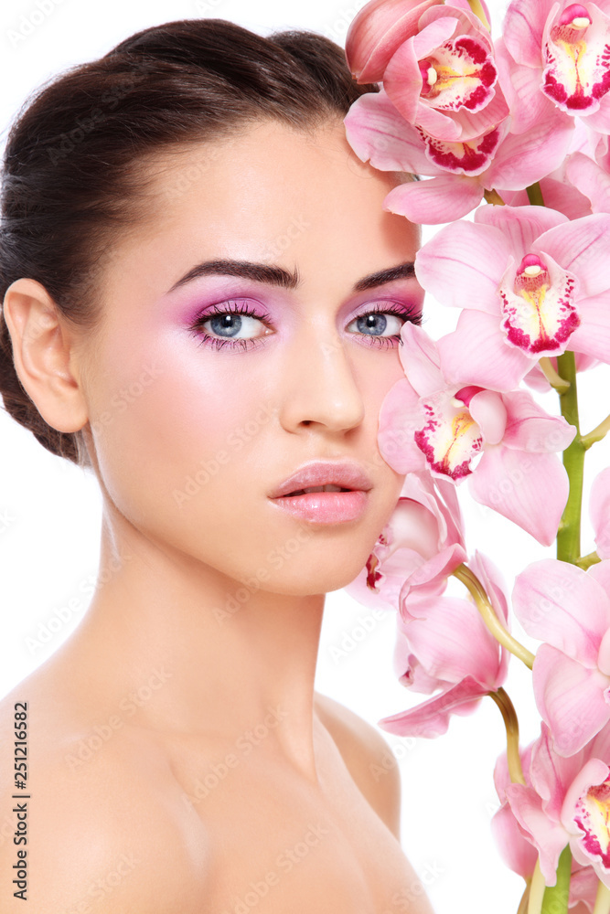 Young beautiful woman with pink make-up and orchid flower