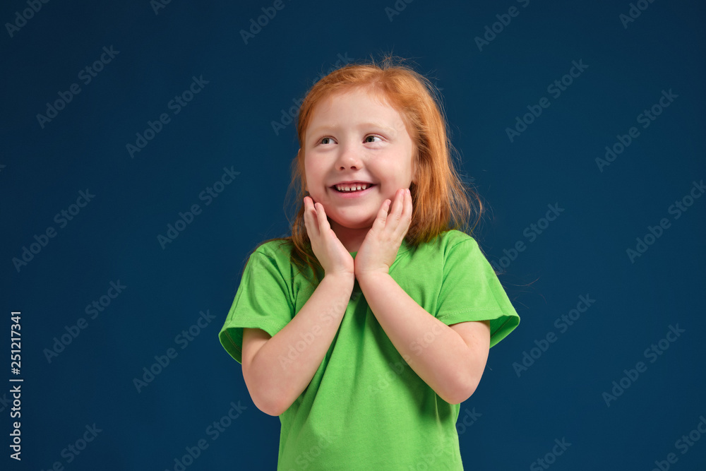 close up photo of little redhead emotional girl posing before camera on blue background close up photo of little redhead emotional girl posing before camera on blue background