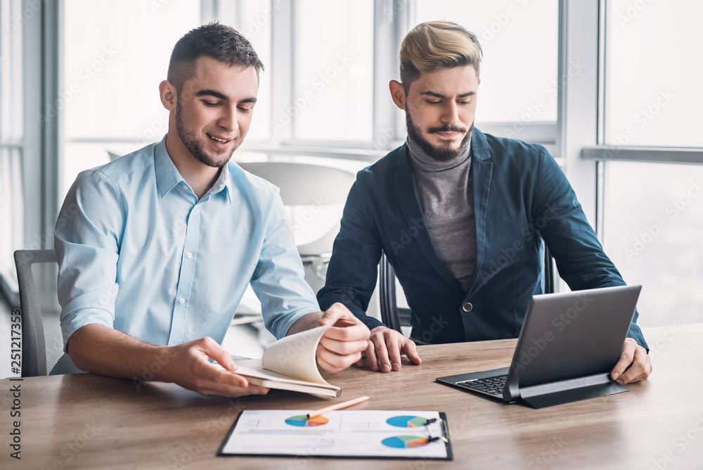 Two businessman in office having discussion in front of computer Two businessman in office having discussion in front of computer