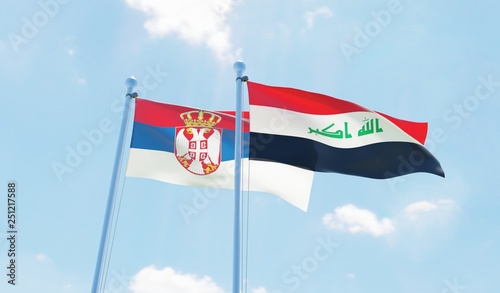 Iraq and Serbia, two flags waving against blue sky. 3d image