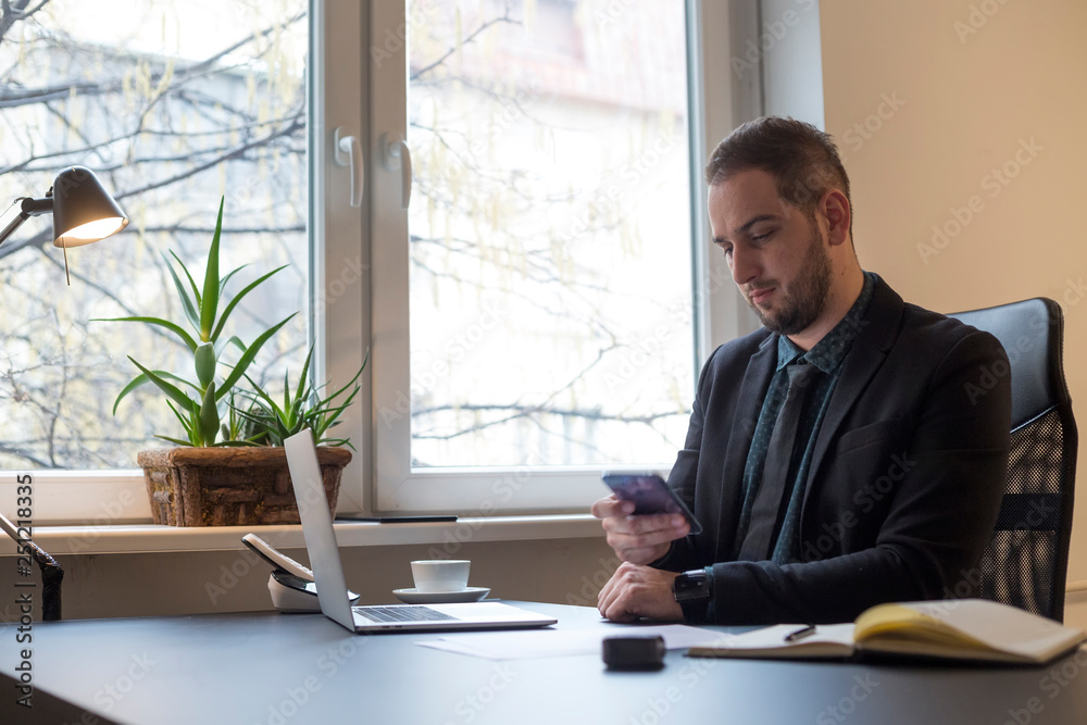 businessman in office sending messages with mobile phone smiling businessman in office sending messages with mobile phone smiling