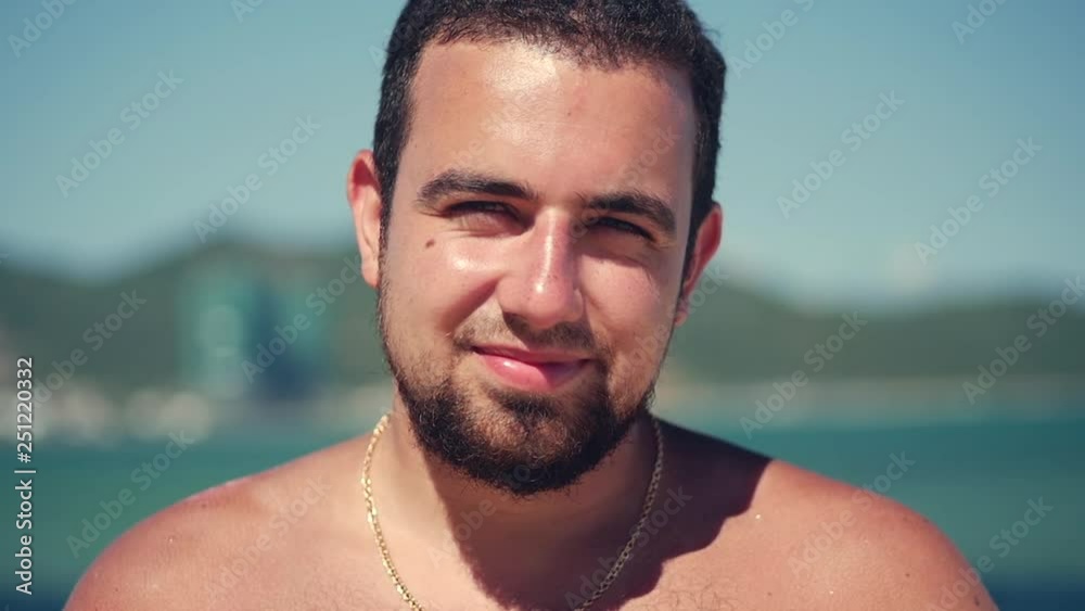 Close Up Portrait Young Caucasian of Handsome Brunette Man a Beard Looking in the Camera Thoughtful, Smiles Pensive, on Blue Sky Background.