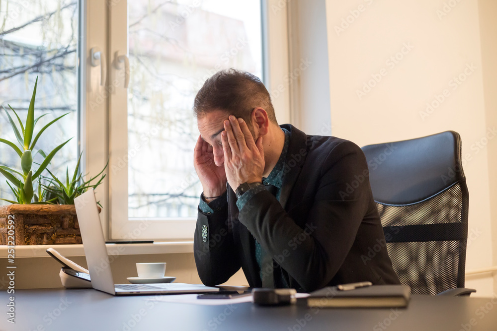 businessman working on laptop in office headache by window black table with notebook papers phone migraine businessman working on laptop in office headache by window black table with notebook papers phone migraine