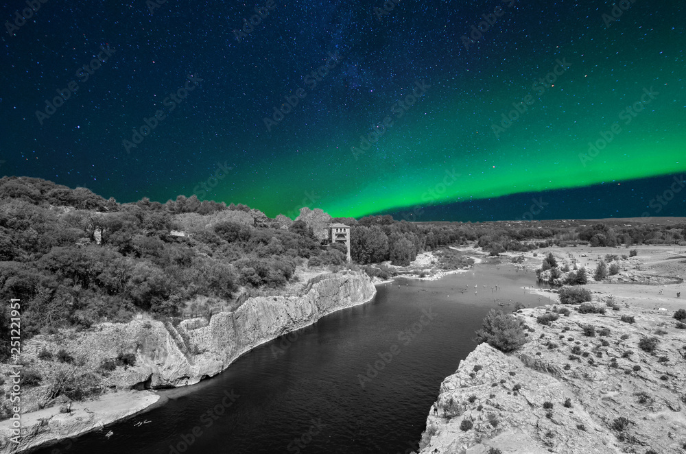 View from the Roman aqueduct in France in black and white, with starry sky and northern lights