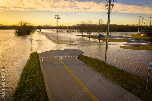 Car is stranded as muddy water flows over the road