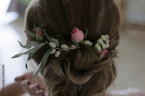 Decoration in the hair of a woman from small pink roses, small white flowers and fruits Elaeagnus commutata
