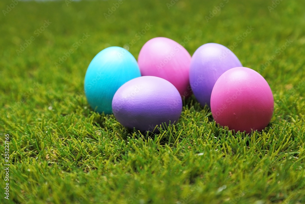 A bunch of colorful Easter eggs on green grass A bunch of colorful Easter eggs on green grass