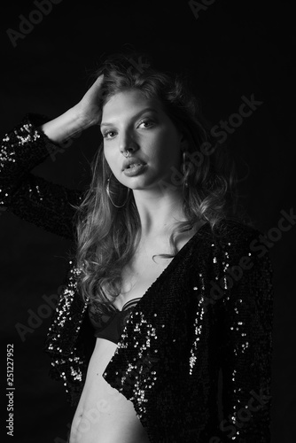 black and white fashion photo of beautiful sexy woman with luxurious curly hair in elegant jacket and lingerie posing in studio