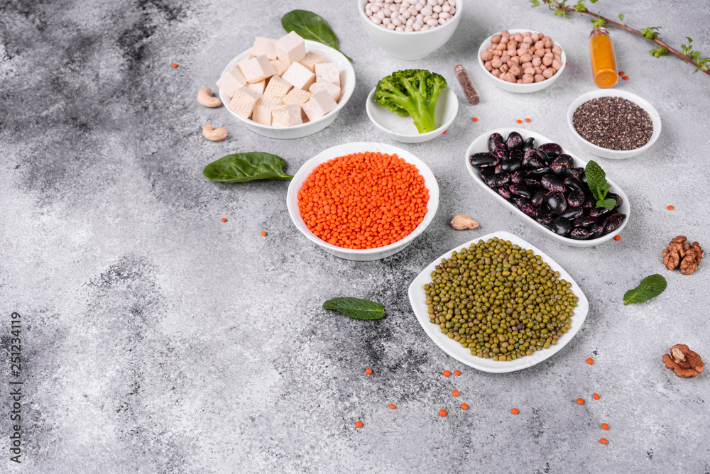 Superfoods on a gray background with copy space. Nuts, beans, greens and seeds. Healthy vegan food Superfoods on a gray background with copy space. Nuts, beans, greens and seeds. Healthy vegan food