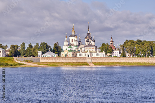 A small church and the bell tower on the banks of the river, Russia