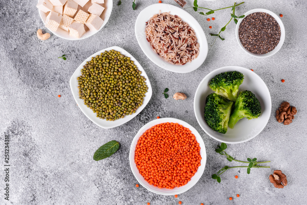 Superfoods on a gray background with copy space. Nuts, beans, greens and seeds. Healthy vegan food Superfoods on a gray background with copy space. Nuts, beans, greens and seeds. Healthy vegan food